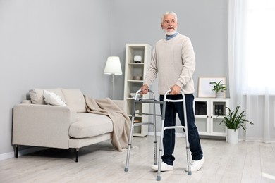 Photo of Senior man using walking frame at home