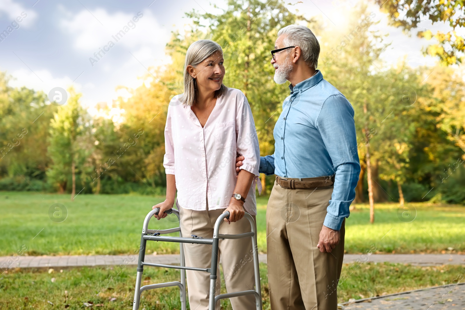 Photo of Senior couple with walking frame in park