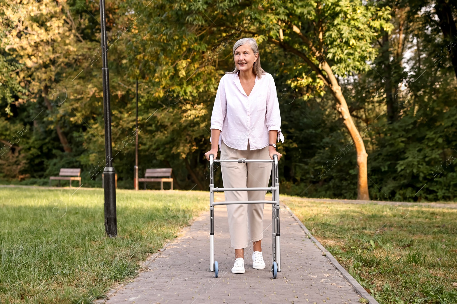 Photo of Senior woman with walking frame in park