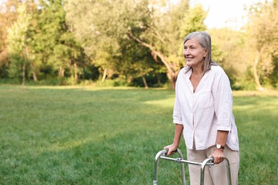 Photo of Senior woman with walking frame in park, space for text