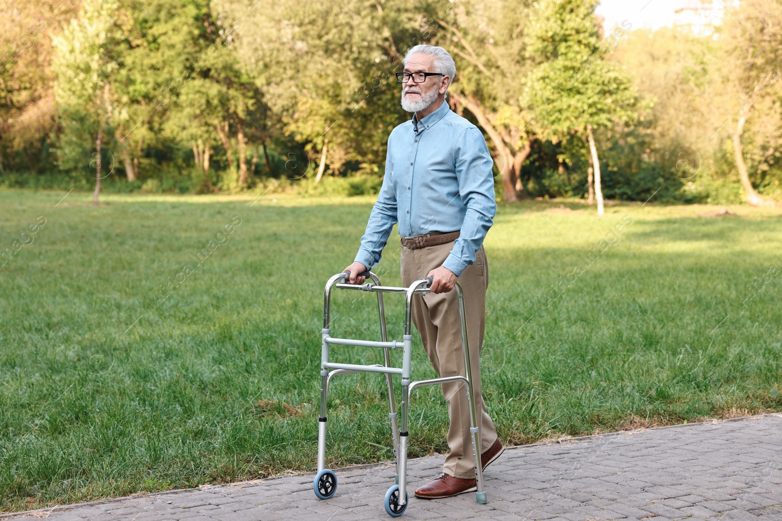 Photo of Senior man with walking frame in park