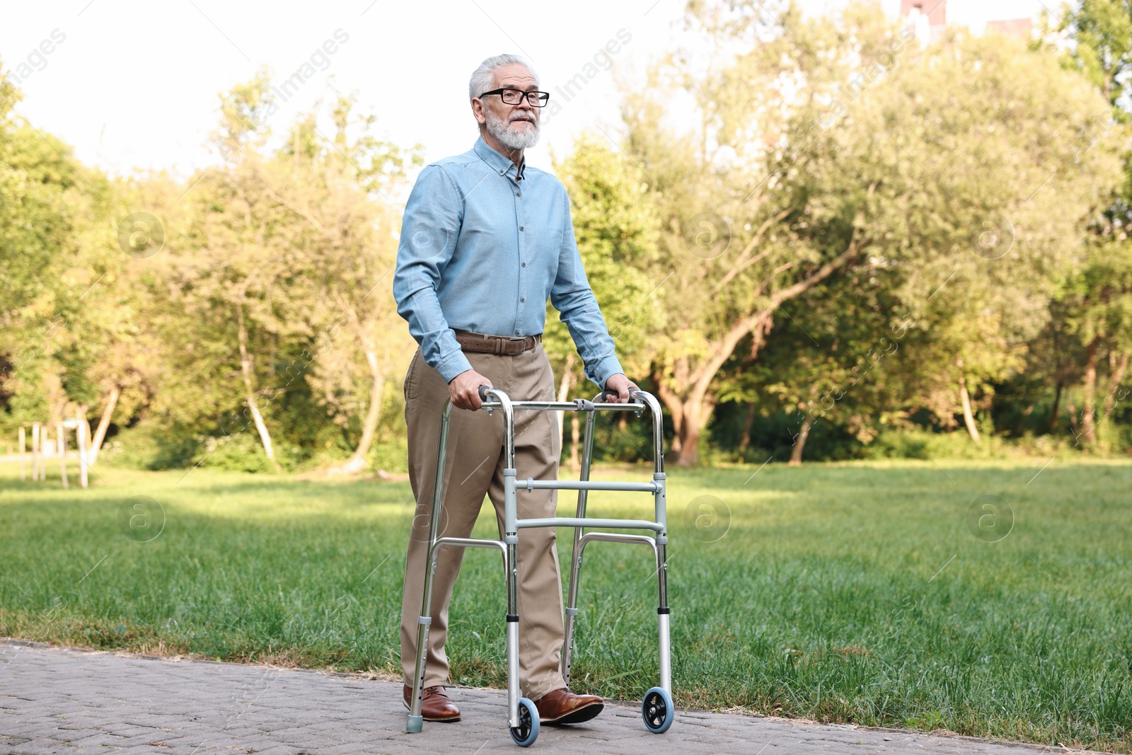 Photo of Senior man with walking frame in park