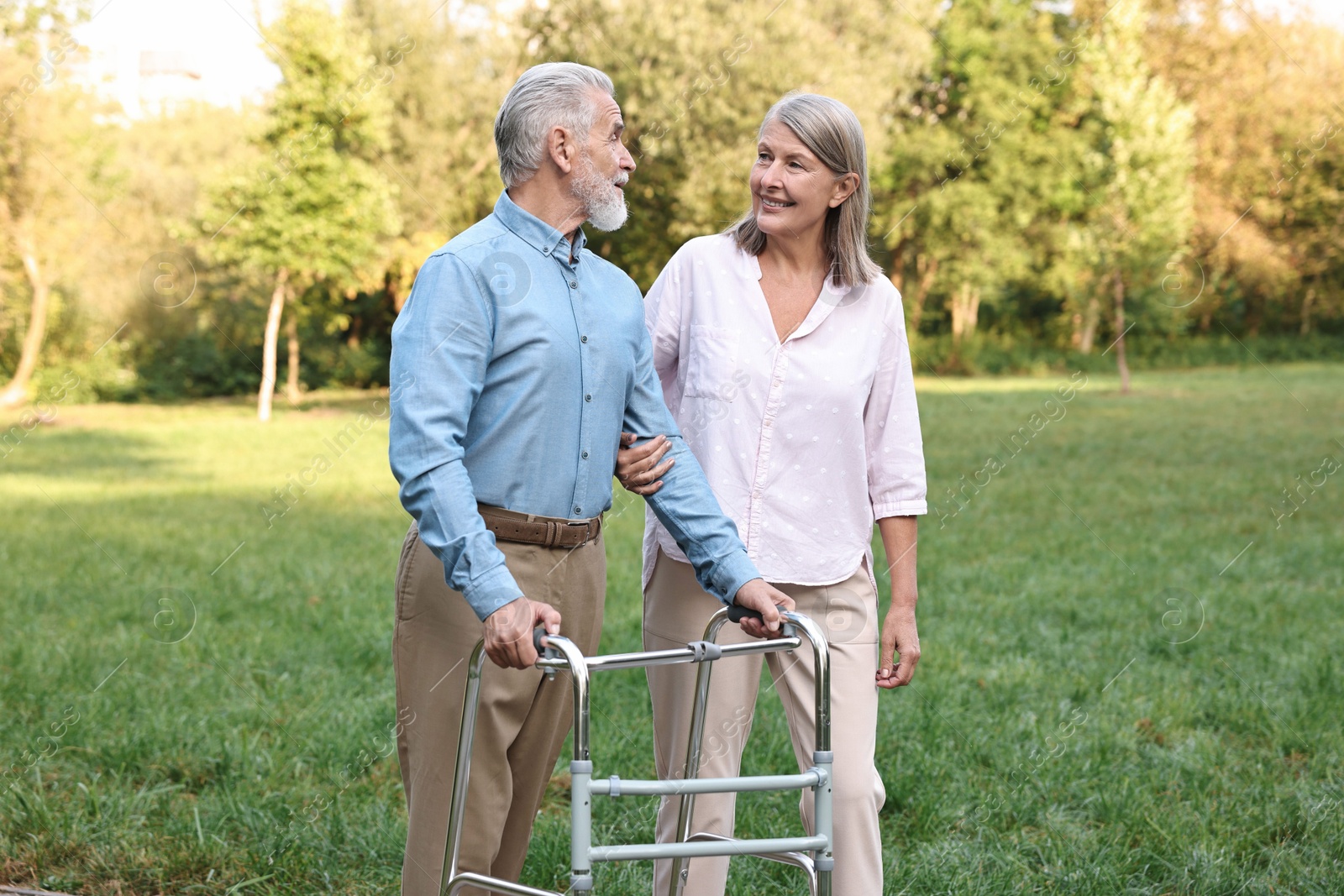 Photo of Senior couple with walking frame in park