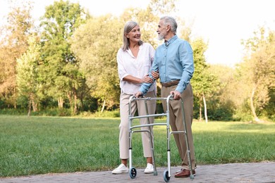 Photo of Senior couple with walking frame in park