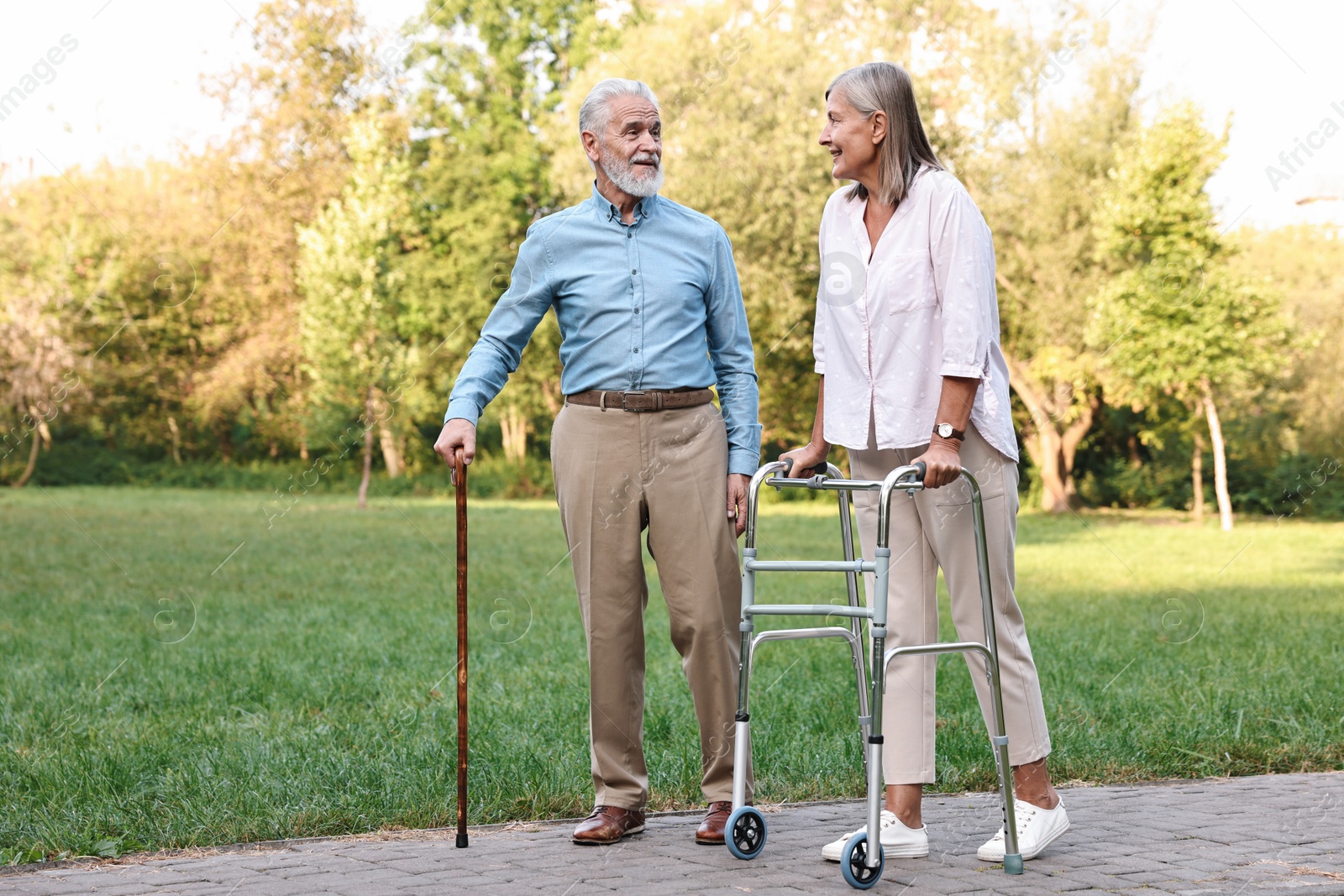 Photo of Senior couple with walking frame and cane in park