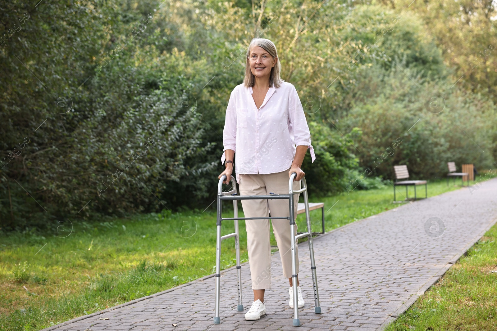 Photo of Senior woman with walking frame in park