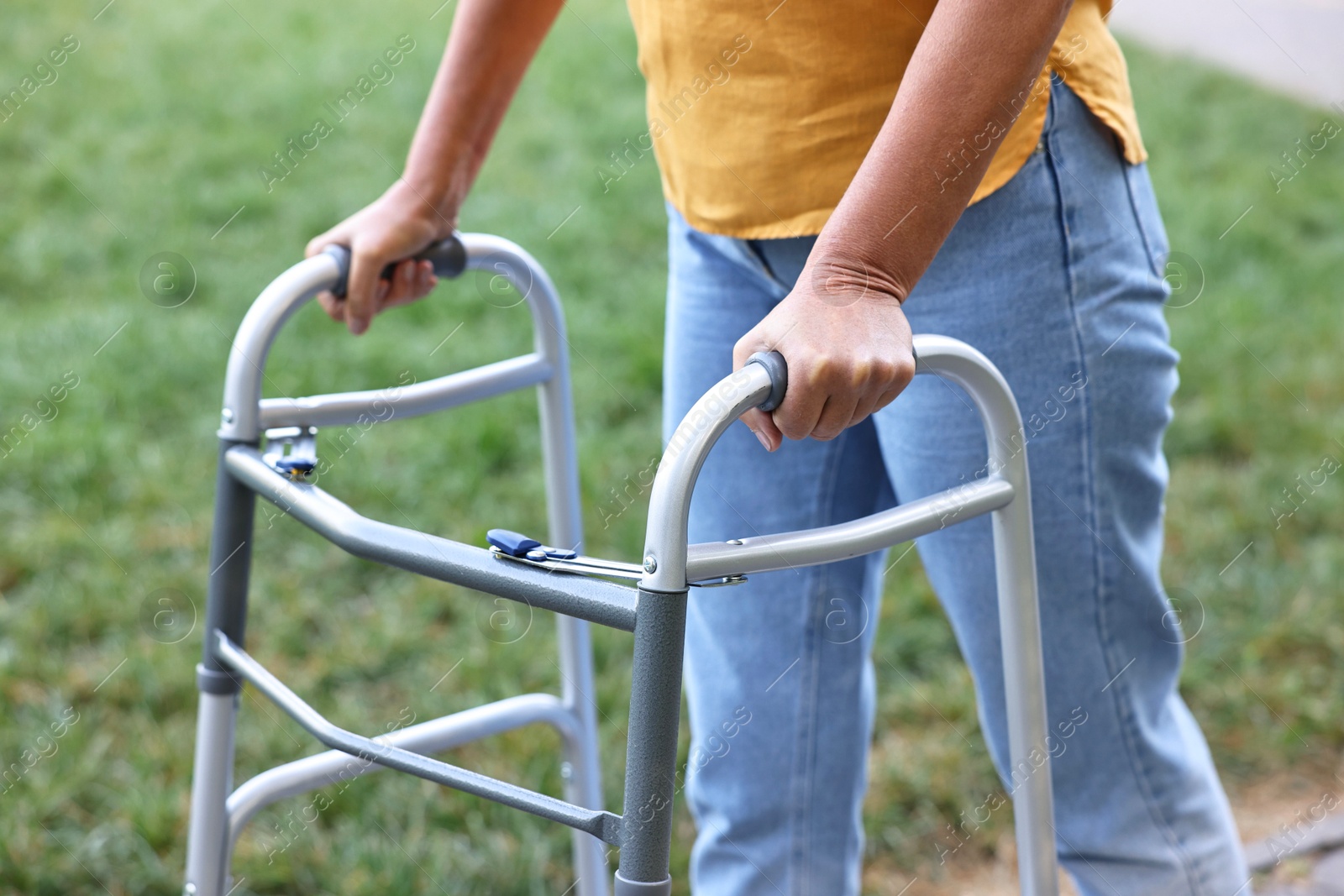 Photo of Senior woman with walking frame in park, closeup