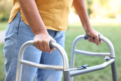 Photo of Senior woman with walking frame in park, closeup