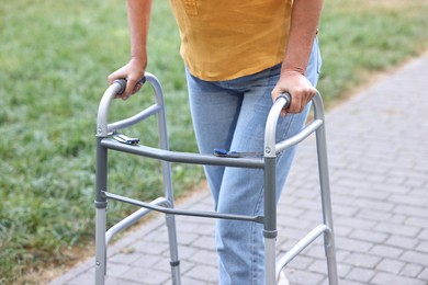 Photo of Senior woman with walking frame in park, closeup