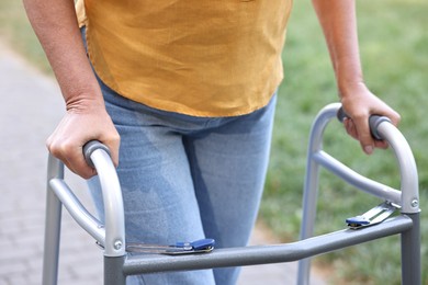 Photo of Senior woman with walking frame in park, closeup