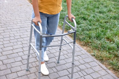 Photo of Senior woman with walking frame in park, closeup