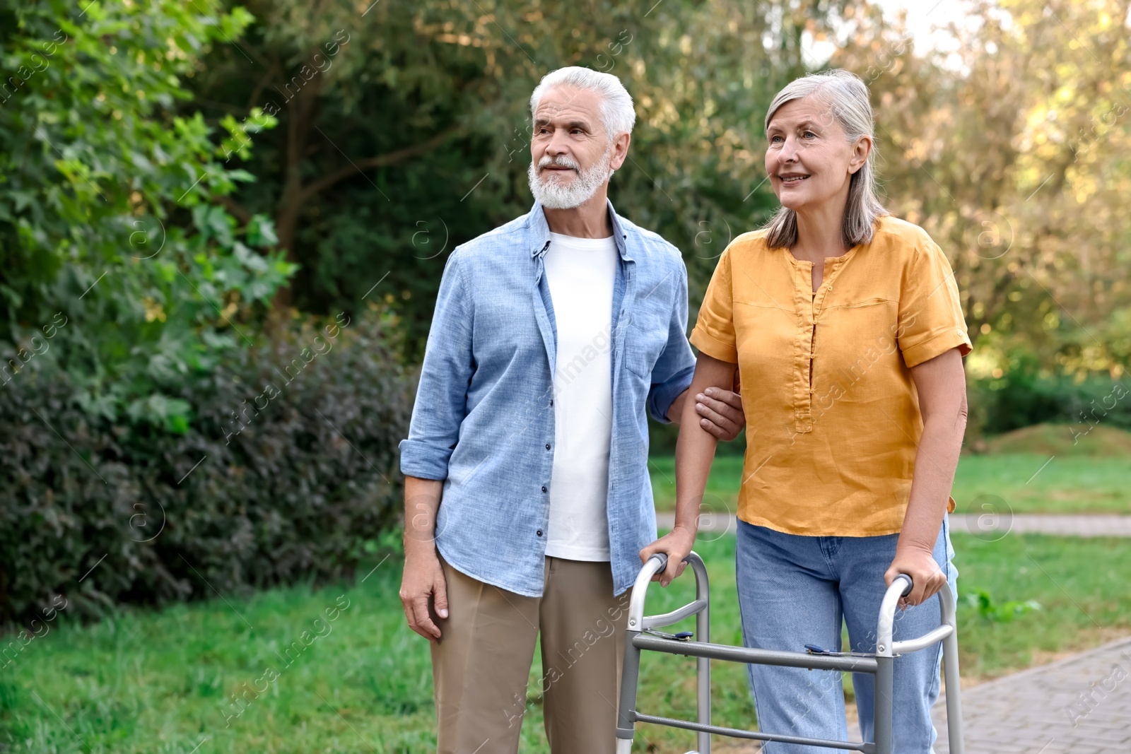 Photo of Senior couple with walking frame in park