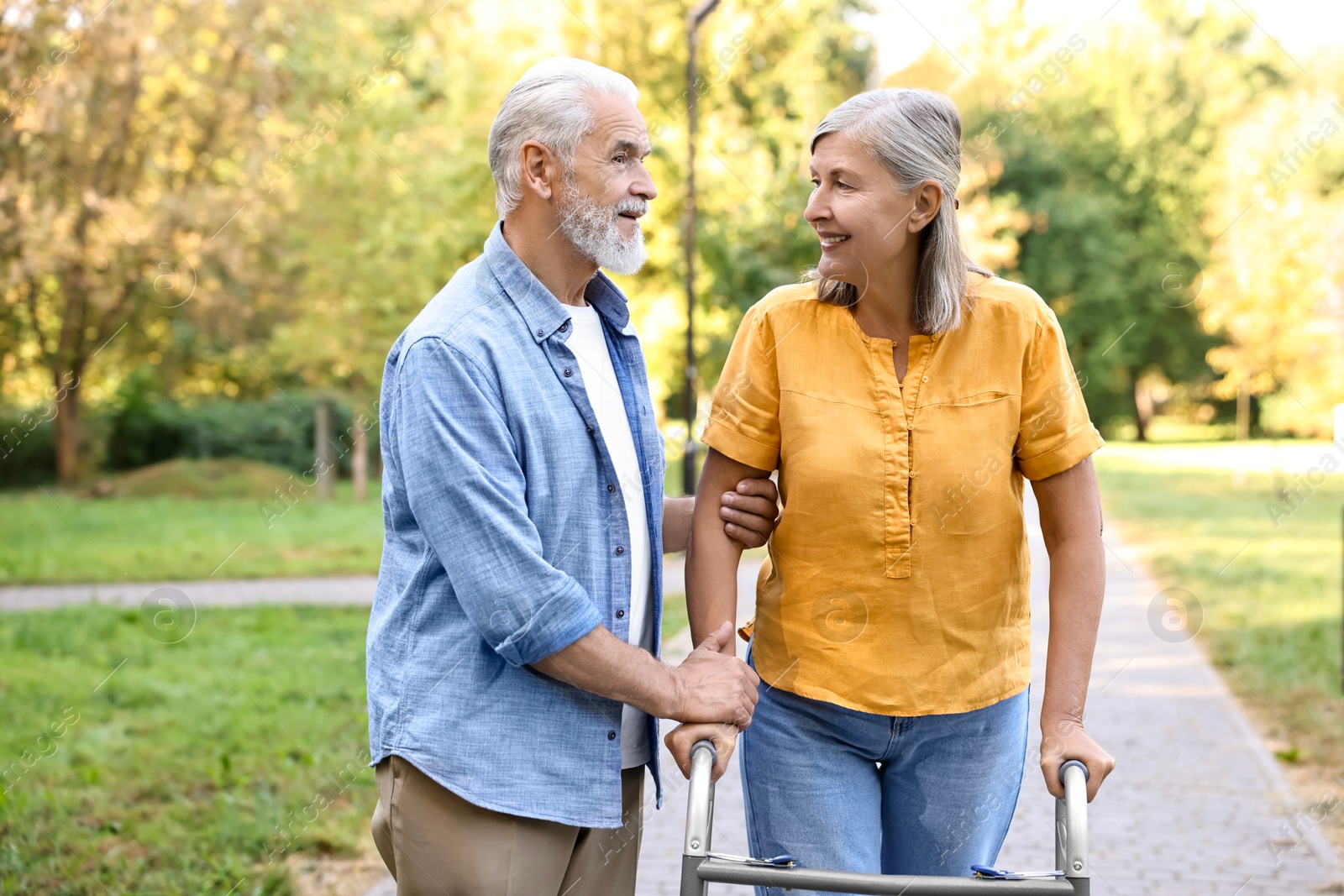 Photo of Senior couple with walking frame in park