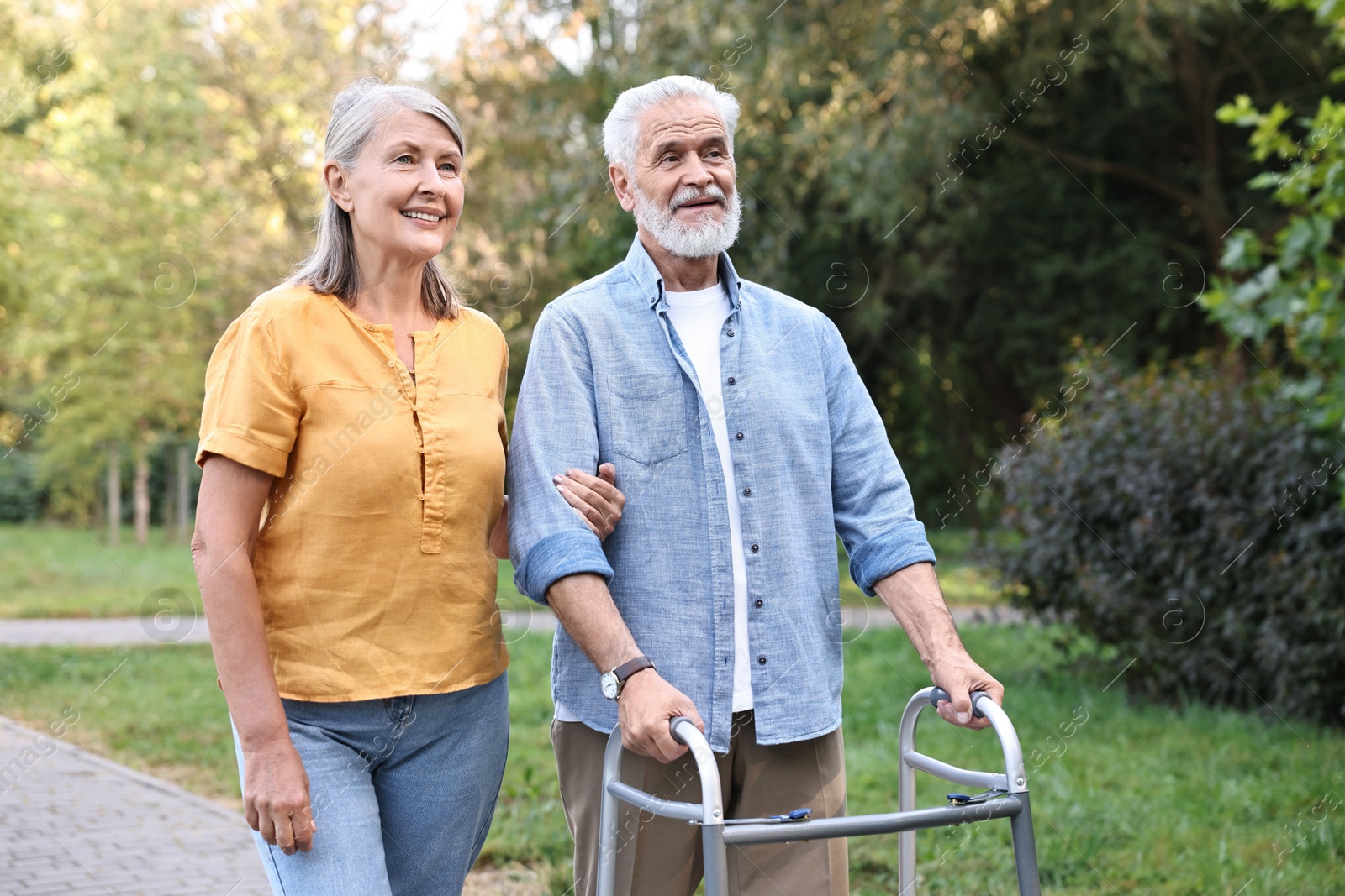 Photo of Senior couple with walking frame in park