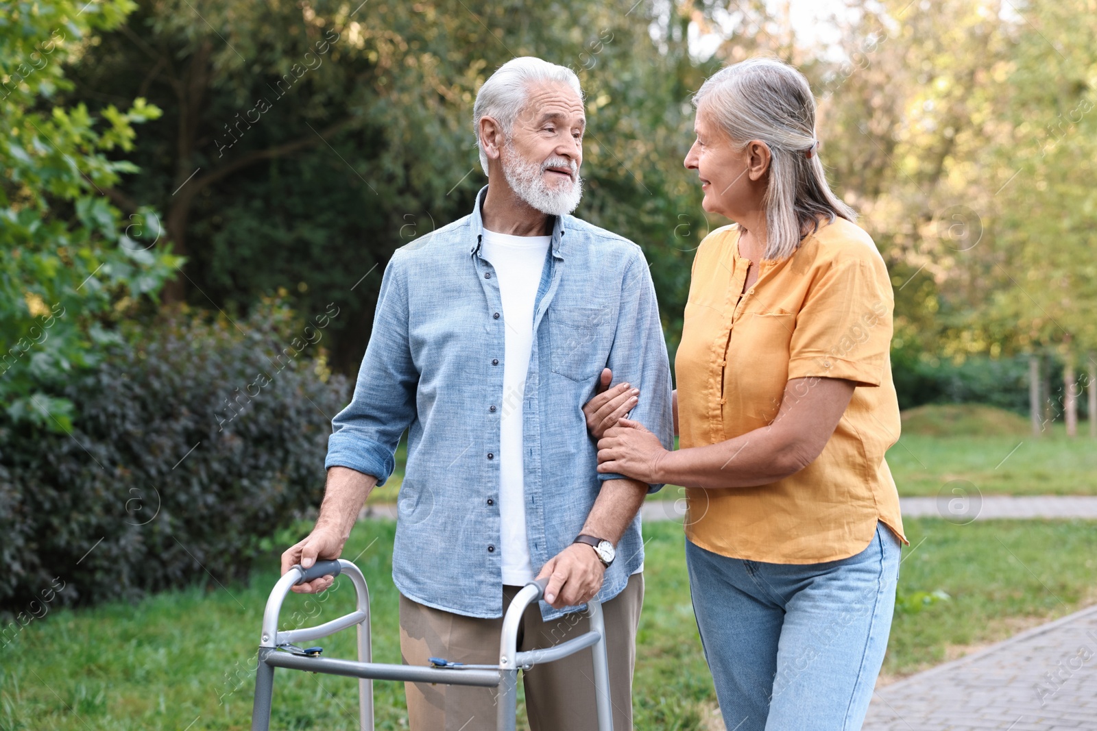 Photo of Senior couple with walking frame in park