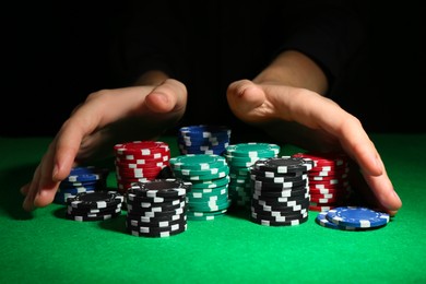 Photo of Woman with poker chips at green table, closeup