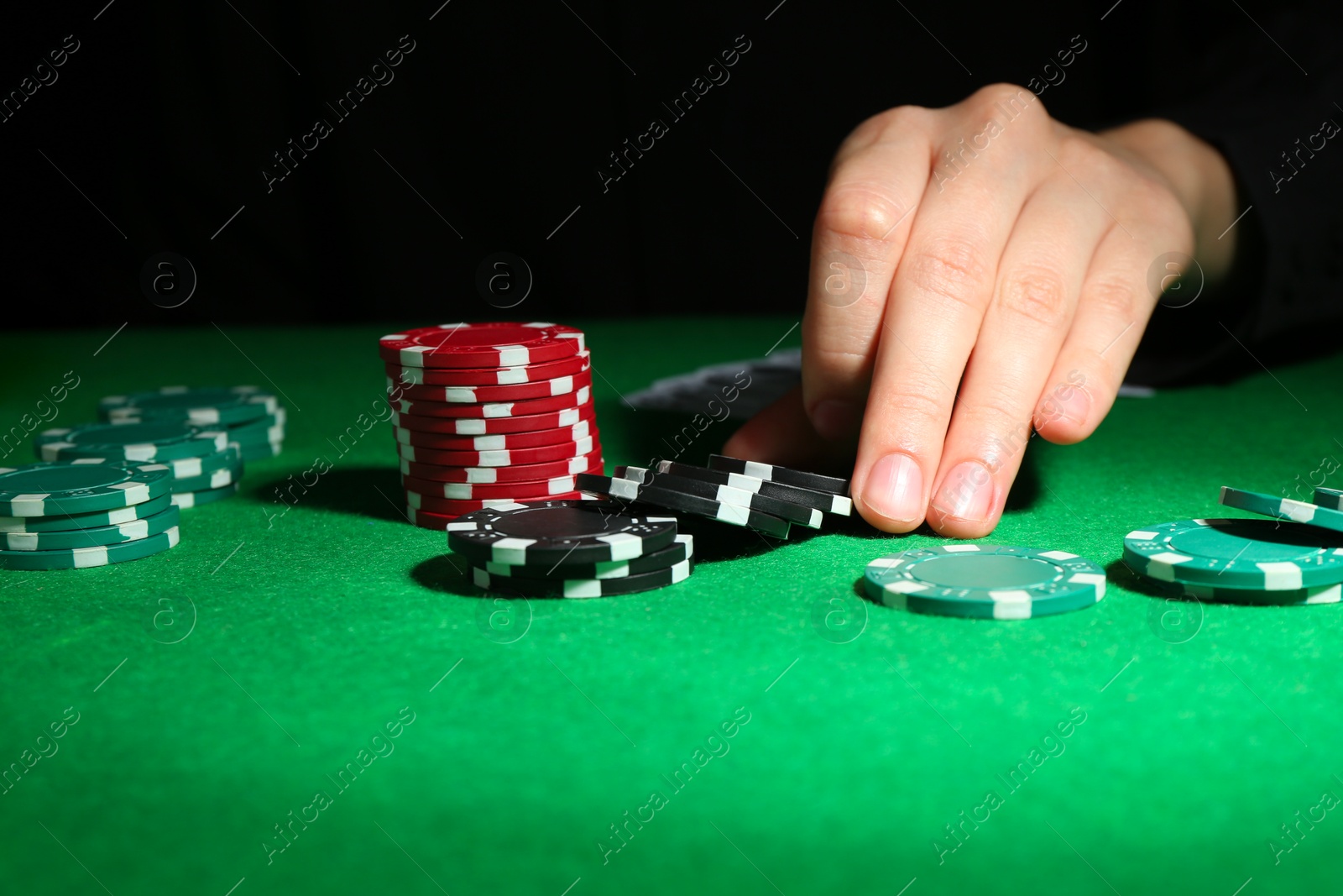 Photo of Woman with poker chips at green table, closeup