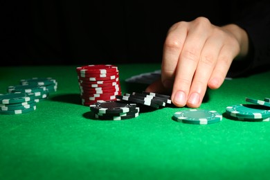 Photo of Woman with poker chips at green table, closeup