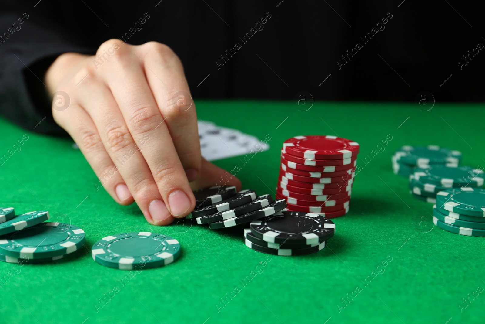 Photo of Woman with poker chips at green table, closeup