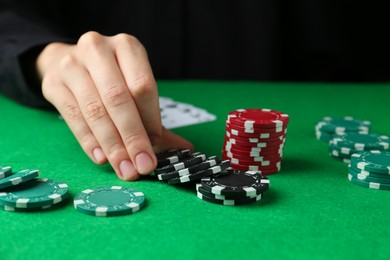 Woman with poker chips at green table, closeup