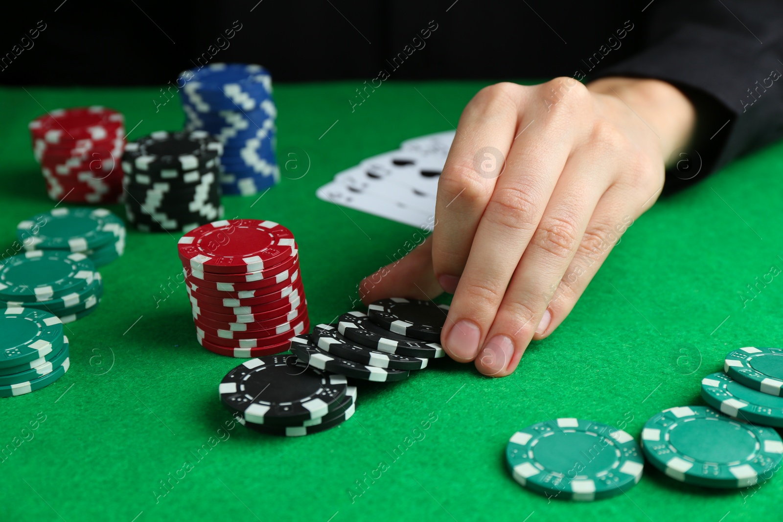 Photo of Woman with poker chips at green table, closeup