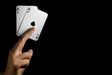 Woman with playing cards against black background, closeup. Space for text