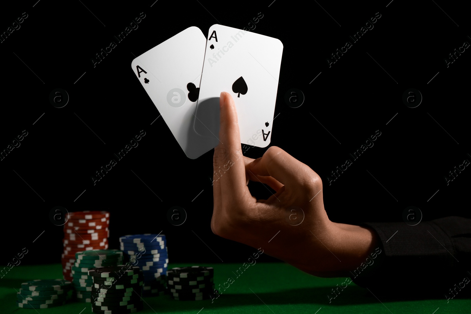 Photo of Woman with playing cards and poker chips at green table, closeup