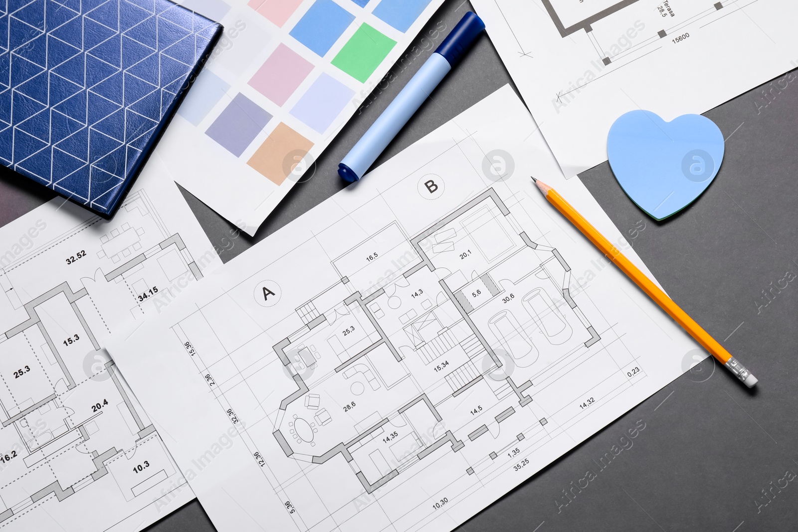 Photo of Designer's workplace with house plans, color palettes and stationery on grey table, flat lay