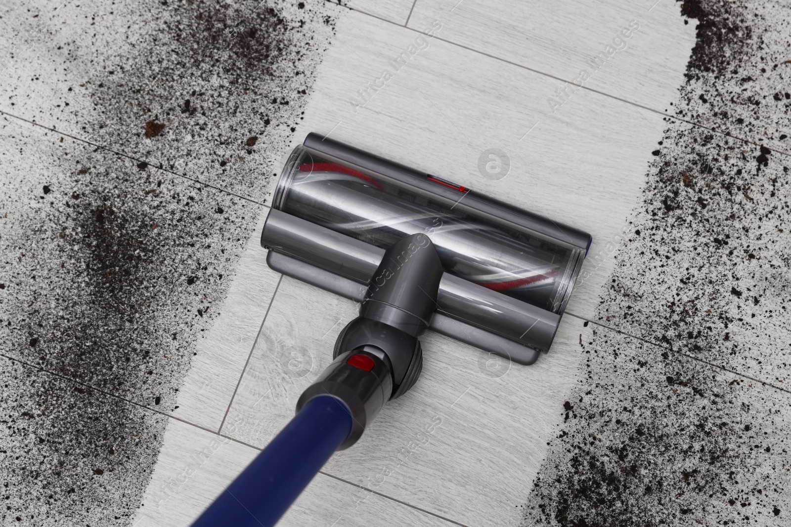 Photo of Cleaning floor with cordless vacuum cleaner indoors, top view