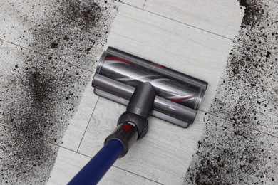 Photo of Cleaning floor with cordless vacuum cleaner indoors, top view