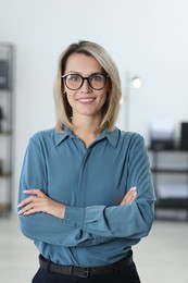 Photo of Portrait of happy businesswoman with crossed arms in office