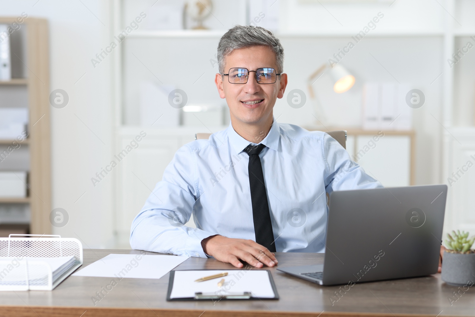 Photo of Portrait of businessman at table in office