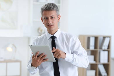 Photo of Portrait of businessman using tablet in office