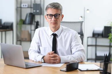 Photo of Portrait of businessman at table in office