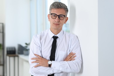 Photo of Portrait of businessman with crossed arms in office