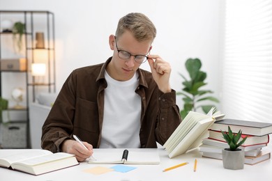 Photo of Student preparing for exam at table indoors