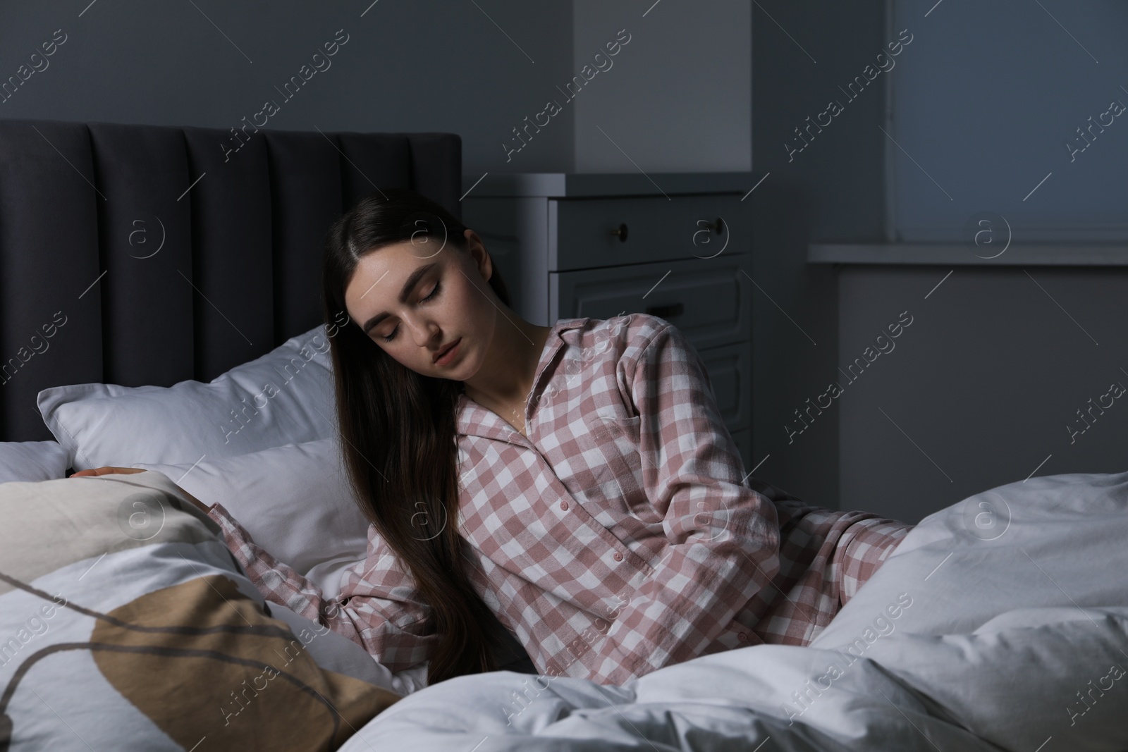 Photo of Young woman suffering from sleepwalking on bed at home