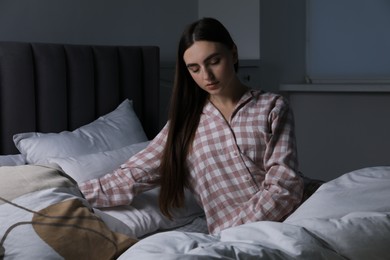 Photo of Young woman suffering from sleepwalking on bed at home