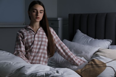 Photo of Young woman suffering from sleepwalking on bed at home