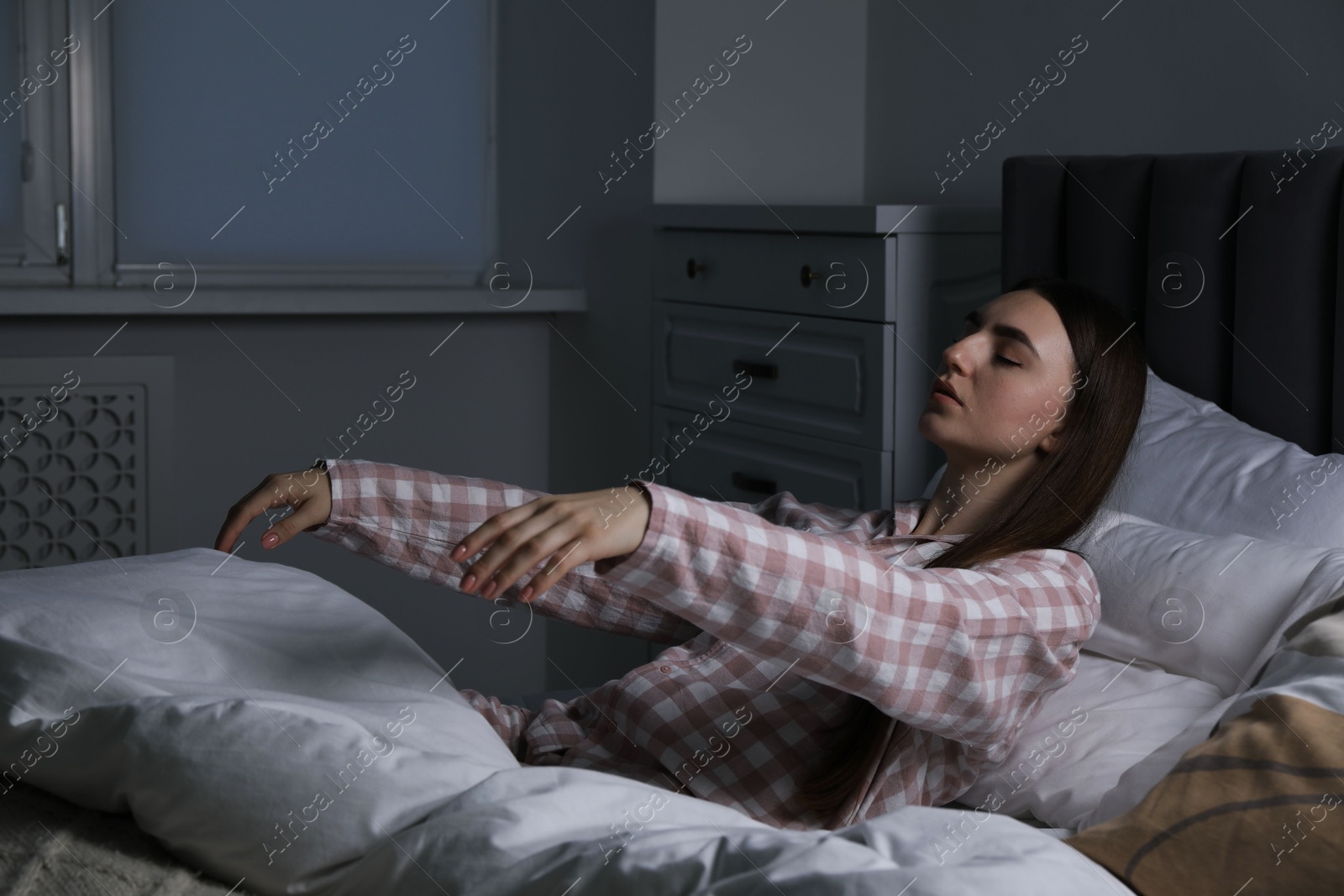 Photo of Young woman suffering from sleepwalking on bed at home