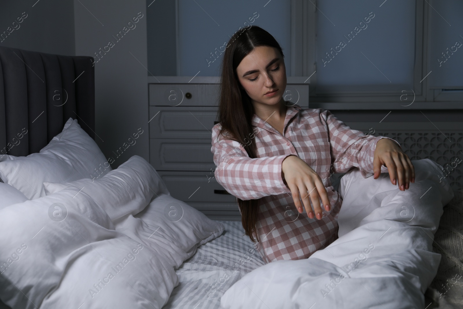 Photo of Young woman suffering from sleepwalking on bed at home