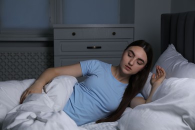 Photo of Young woman suffering from sleepwalking on bed at home