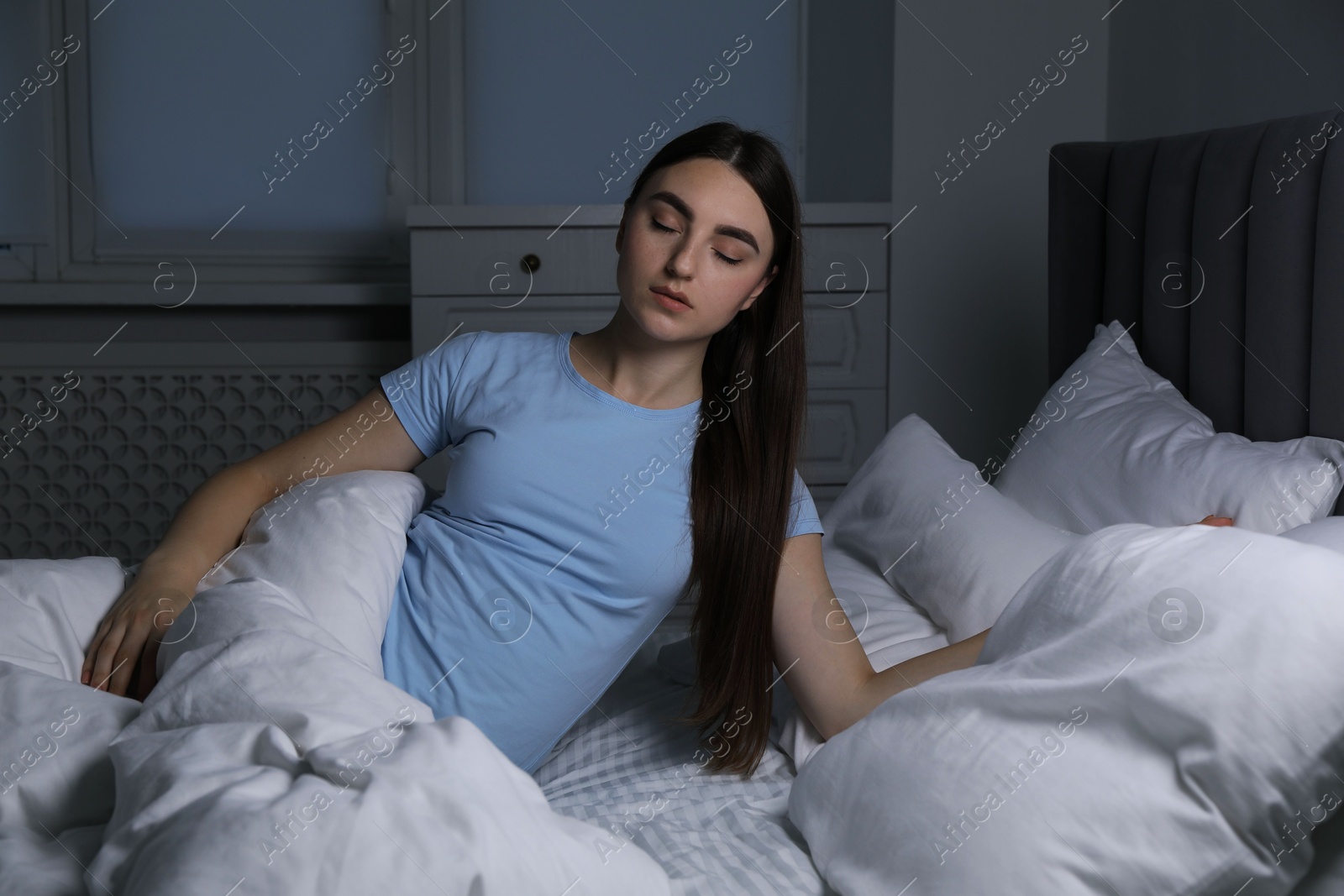 Photo of Young woman suffering from sleepwalking on bed at home