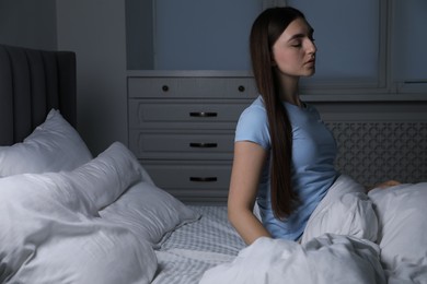 Photo of Young woman suffering from sleepwalking on bed at home