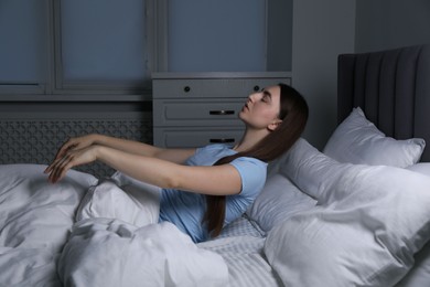 Photo of Young woman suffering from sleepwalking on bed at home