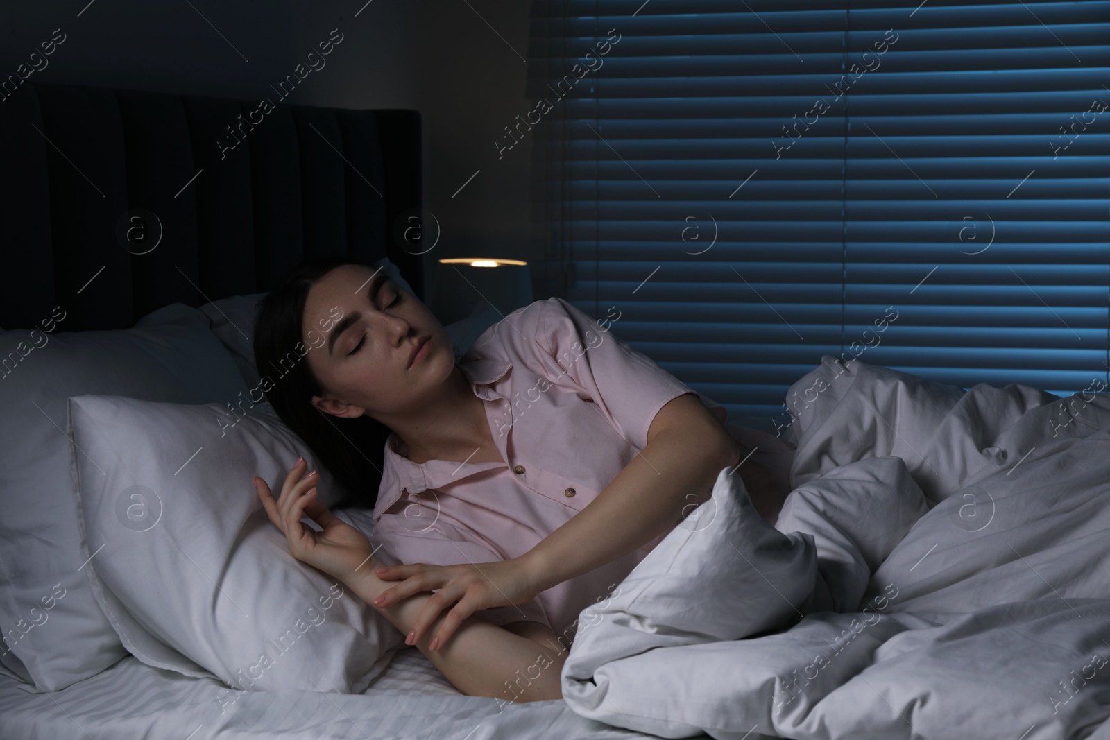 Photo of Young woman suffering from sleepwalking on bed at home