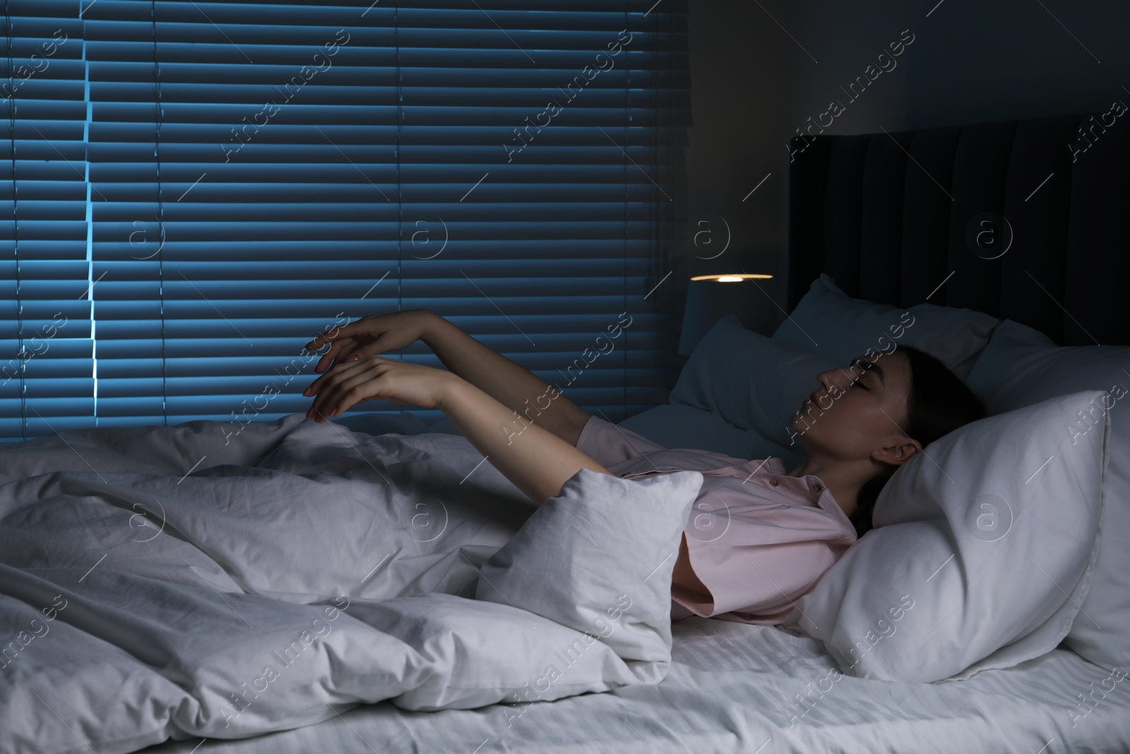 Photo of Young woman suffering from sleepwalking on bed at home