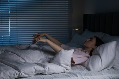 Photo of Young woman suffering from sleepwalking on bed at home