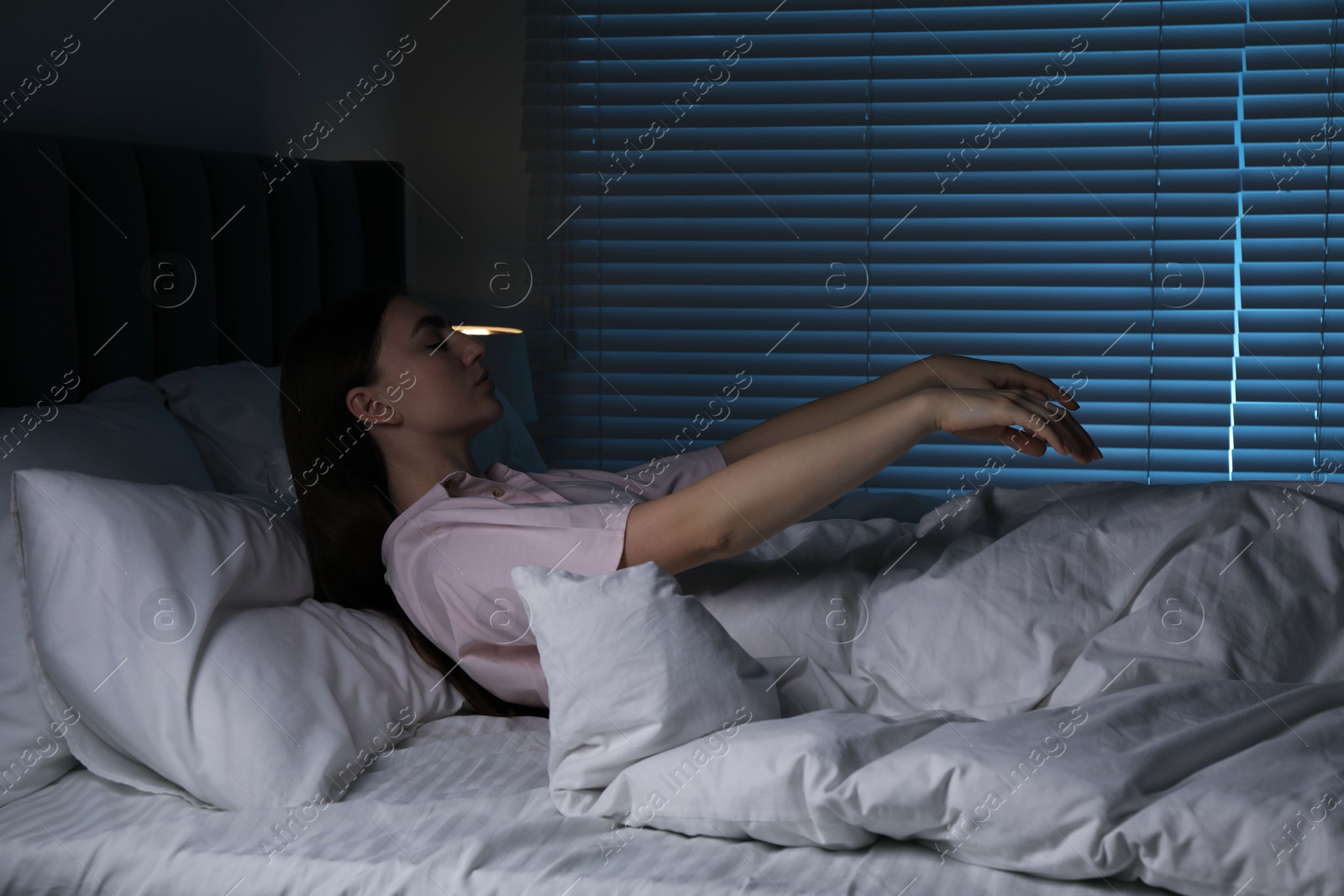 Photo of Young woman suffering from sleepwalking on bed at home