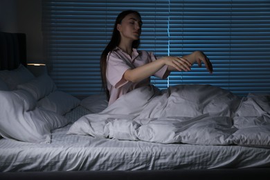 Photo of Young woman suffering from sleepwalking on bed at home